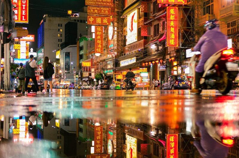 a person riding a motorcycle on a city street at night
