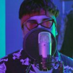 Man in Purple and White Floral Shirt Wearing Headphones