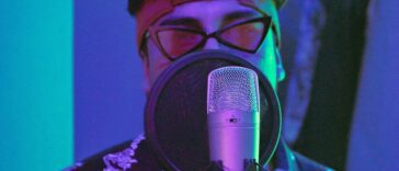 Man in Purple and White Floral Shirt Wearing Headphones