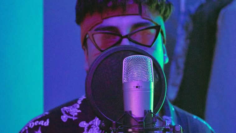 Man in Purple and White Floral Shirt Wearing Headphones