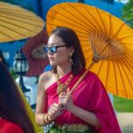 woman in red dress wearing sunglasses holding umbrella