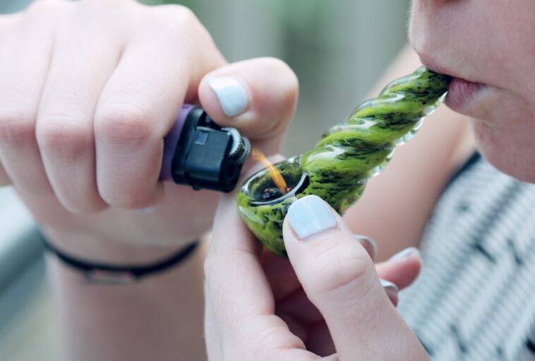 person holding lighting spoon pipe