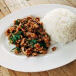 Stir Fried Thai Basil with Minced Pork and Rice on Oval Ceramic Plate