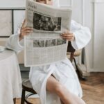A Woman Reading A Newspaper in Her Bathrobe