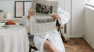 A Woman Reading A Newspaper in Her Bathrobe
