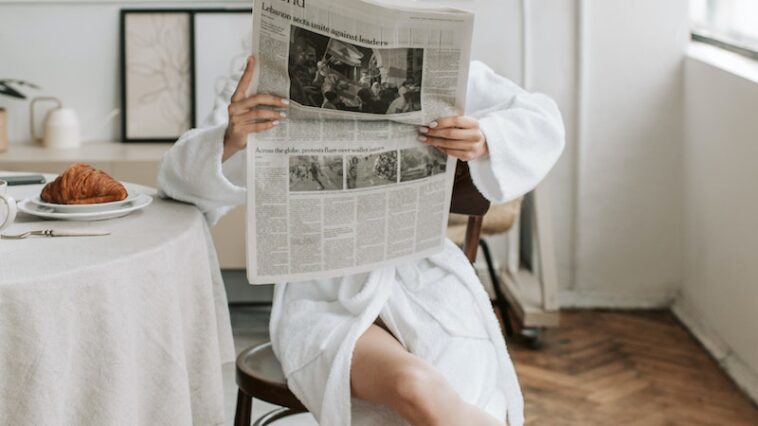 A Woman Reading A Newspaper in Her Bathrobe
