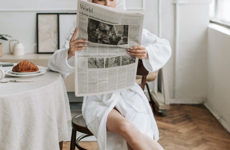 A Woman Reading A Newspaper in Her Bathrobe