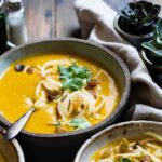 three noodle dishes with orange sauces in food photography