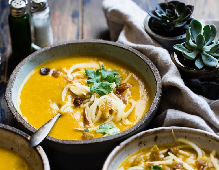 three noodle dishes with orange sauces in food photography