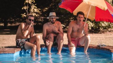 man and woman sitting on swimming pool during daytime