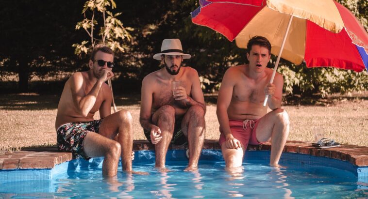 man and woman sitting on swimming pool during daytime