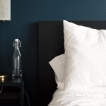 gray table lamp beside white bed pillow