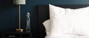 gray table lamp beside white bed pillow