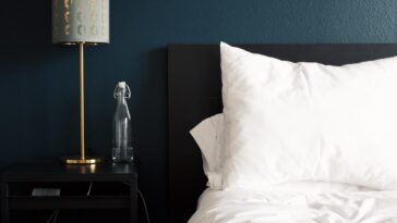gray table lamp beside white bed pillow