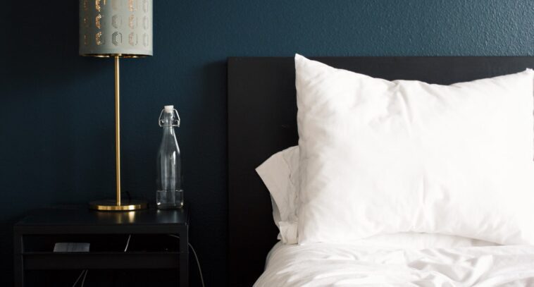 gray table lamp beside white bed pillow