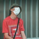 man in red crew neck t-shirt wearing white sunglasses sitting on black chair