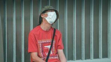 man in red crew neck t-shirt wearing white sunglasses sitting on black chair