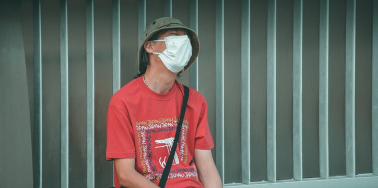 man in red crew neck t-shirt wearing white sunglasses sitting on black chair