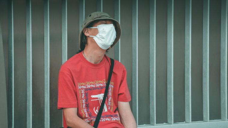 man in red crew neck t-shirt wearing white sunglasses sitting on black chair