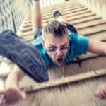 man in blue t-shirt and blue denim shorts sitting on concrete stairs during daytime