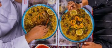 Top View of People Sitting and Eating a Dish with Rice