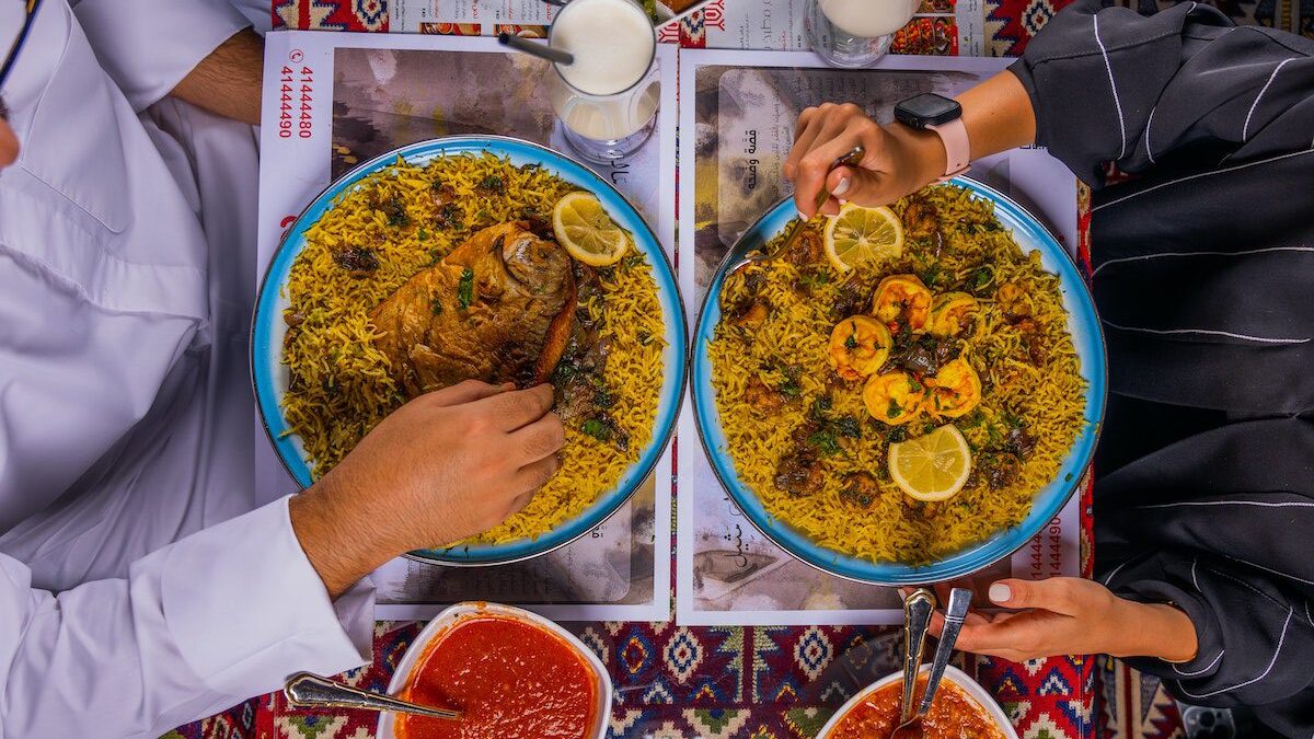 Top View of People Sitting and Eating a Dish with Rice